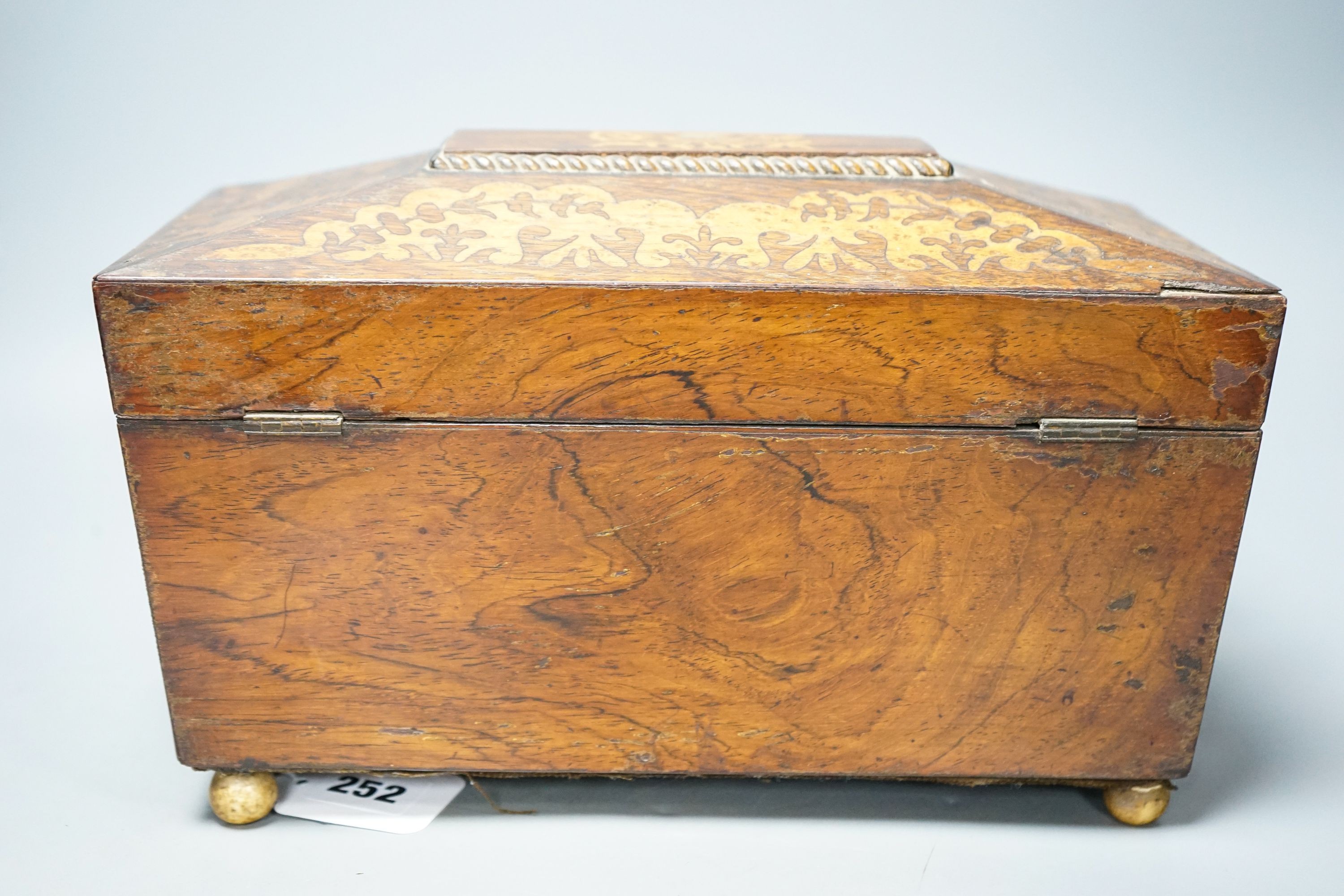 A 19th century rosewood and bird’s eye maple tea caddy, of sarcophagus form, the interior with mixing bowl, on ball feet 31cm